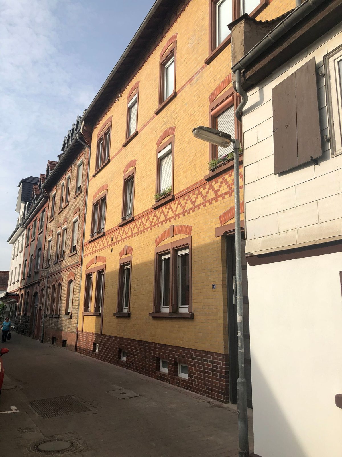 Dieselbe Klinkerfassade nach der Sanierung: gereinigt, Fugen und Zierband frisch, Fenstergewände neu gestrichen